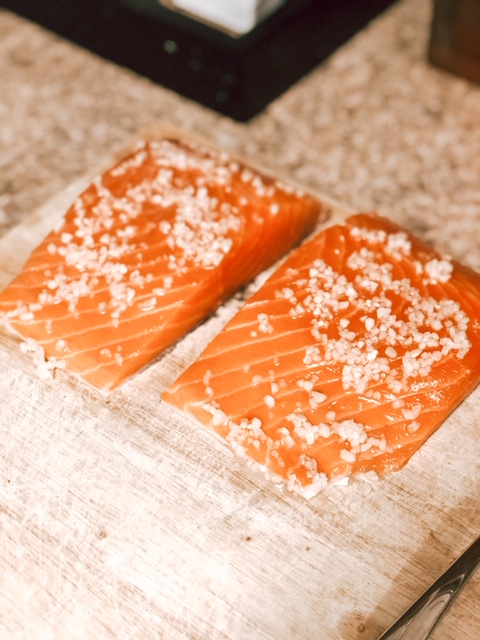 two raw filet of salmon with minced garlic rubbed on them