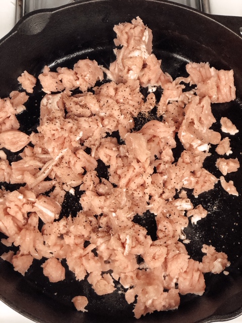 ground turkey meat cooking in a cast iron skillet 