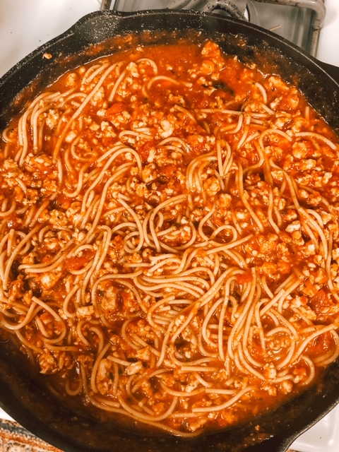 spaghetti sauce and noodles mixture in a cast iron skillet 