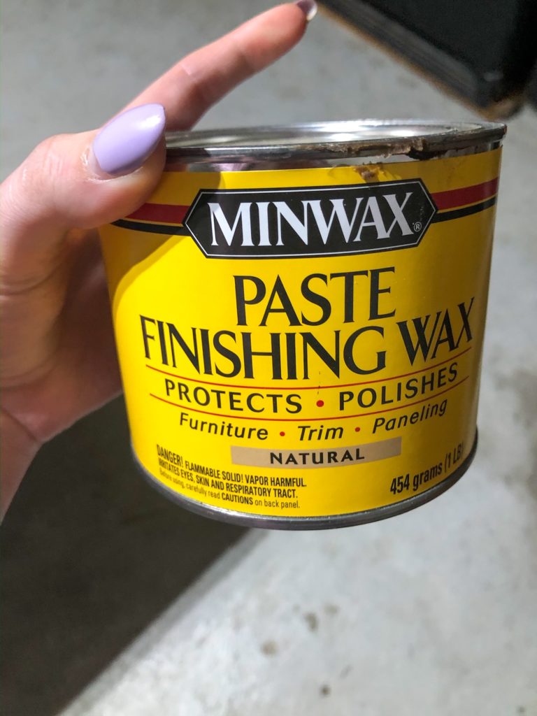 hand holding minwax natural colored finishing was paste after whitewash